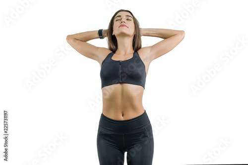 Young woman enjoys sports eyes closed, in black sportswear, isolated on white background