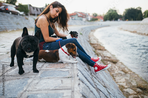 Photography Dog walker with dogs enjoying outdoors next to city river.