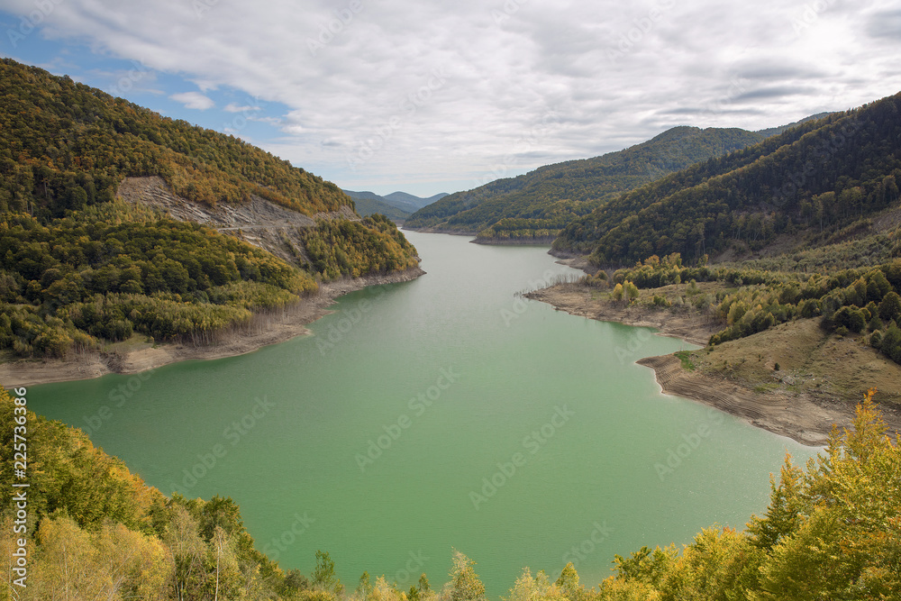 Naklejka premium Mesmerizing view of turquoise lake framed by the forest trees. Alpine beauty shot at the end of september