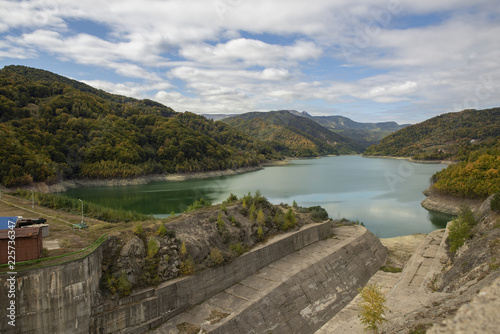 Beautiful turquise lake and forest in the autumn colors shot from the dam side