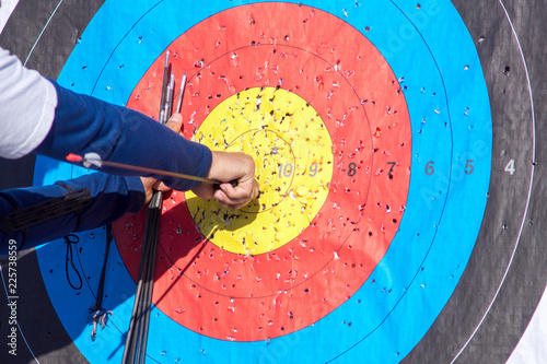 archer pulls arrows from target photo