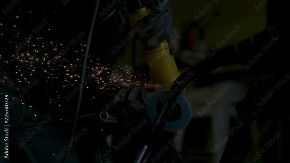 Loop of Angle grinder produces sparks in slow motion. Loop 2 of 2.