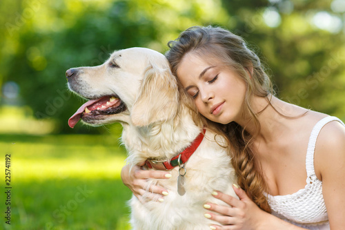 Young woman with golden retriever dog in the summer park © Natalia Chircova