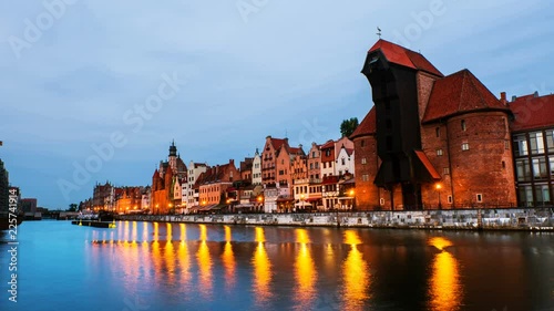 Gdansk, Poland. A sunset time-lapse on 
a cloudy summer morning in the old town of Gdansk, Poland, with boats moored to the enbankment and Brama Żuraw. photo