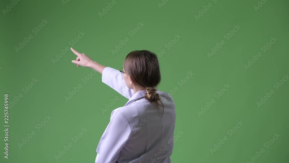Rear view of young beautiful woman doctor pointing finger and directing