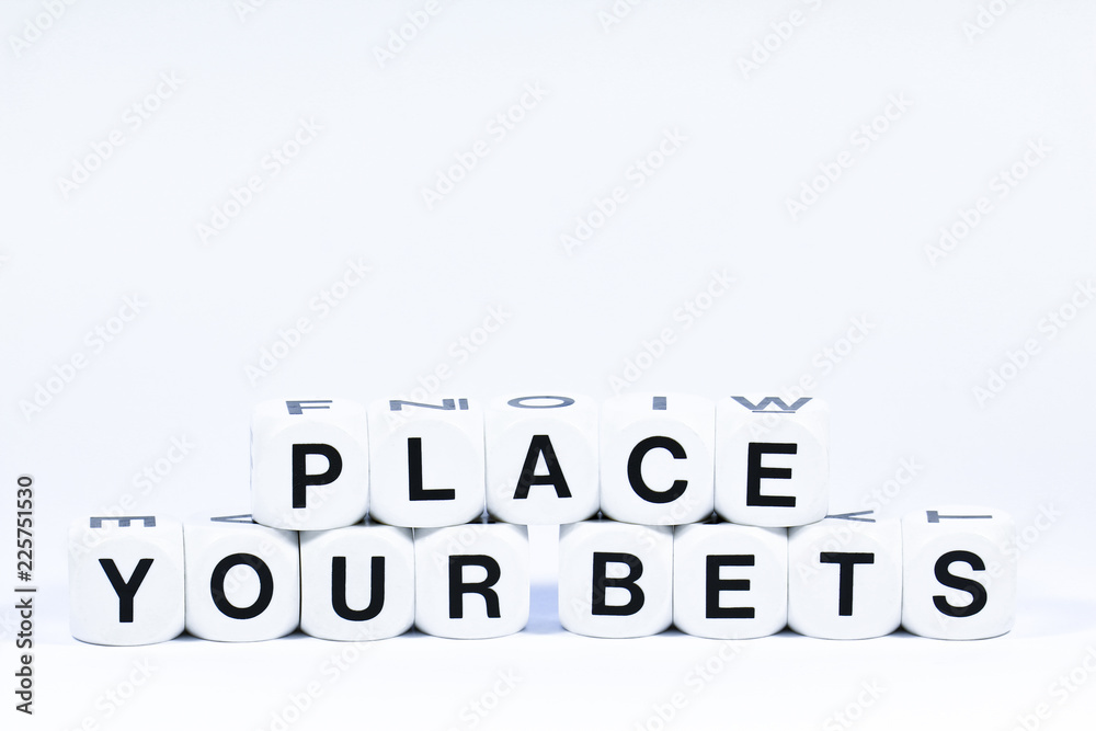 Lettered dice spelling out the phrase place your bets on a white background Lettered dice spelling out the phrase place your bets on a white background