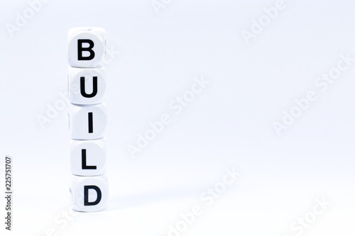 Lettered dice spelling out the word build on a white background