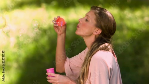 Loop of Woman blowing bubbles in slow motion photo