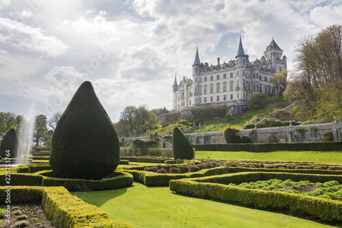 Slika na platnu Old Dunrobin castle in the background and stunning garden with fountain in the foreground
