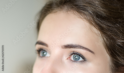 girl with blue eyes looking up, architecture of eyebrows, coloring and correction of eyebrows, registration of eyebrows, blue eyes of the girl