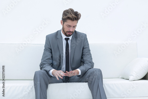 Successful businessman sitting in a suit smokes © ASDF