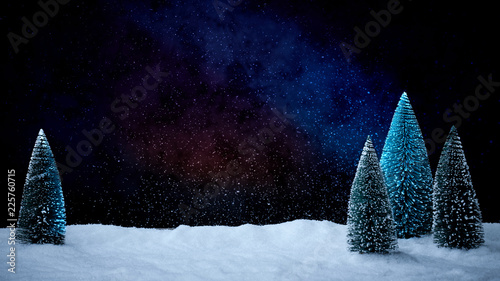 Verschneiter Weihnachtsbaum vor tiefblauem Hinterdrund mit Schnee
