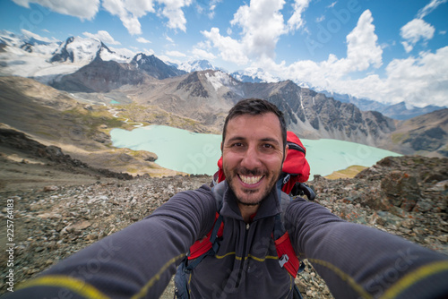 happy man take selfie in Ala Kul lake in Kyrgyzstan, central Asia photo