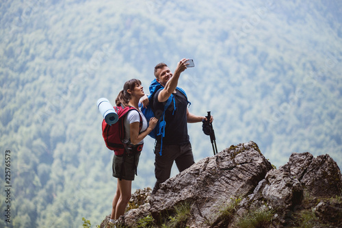 Young Active Couple With Backpack Make Selfie Outdoor At Mountain