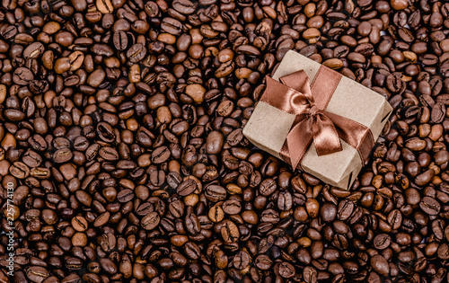 Obraz na płótnie Gift box with ribbon on coffee background. Roasted coffee beans background. Copy space w salonie