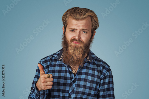 Unhappy man showing giving thumbs up hand gesture. photo