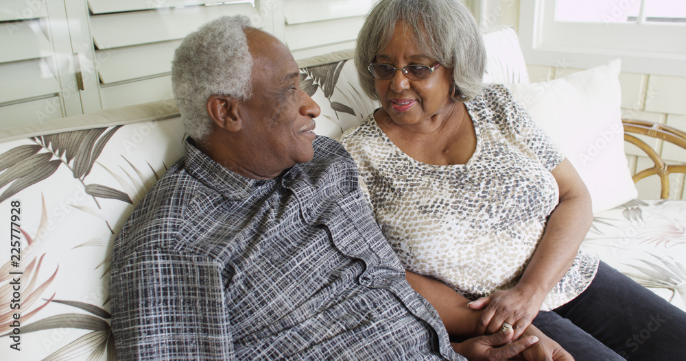 © Mark Adams - Happy retired black couple sitting on a couch © Mark Adams - Happy retired black couple sitting on a couch