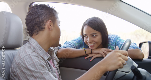Pretty young latina woman smiling at boyfriend in car
