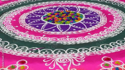 Rangoli with coloured powder being created by Rangoli artist on occasion of Hindu festival, Mumbai, Maharashtra, India.	