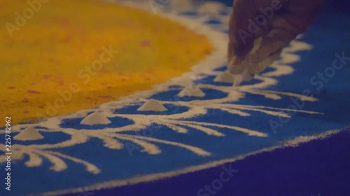 Rangoli with coloured powder being created by Rangoli artist on occasion of Hindu festival, Mumbai, Maharashtra, India.