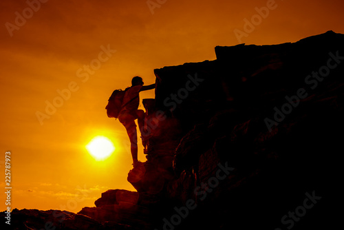 Sporty woman climbing on the cliff. Success and goal concept. Strong and healthy for outdoor activity. Fresh start of day photo