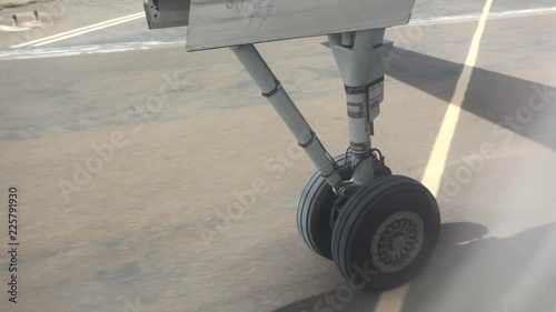 Wheels of aircraft leaving ground at take off at airport runway.