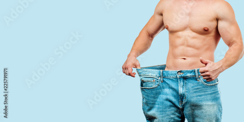 Quadro su tela Man wearing big jeans after diet on blue background