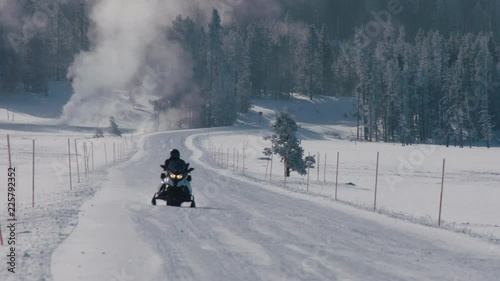 Snowmobile going down snow packed path