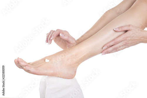 woman apply cream on her bare feet. © Stavros