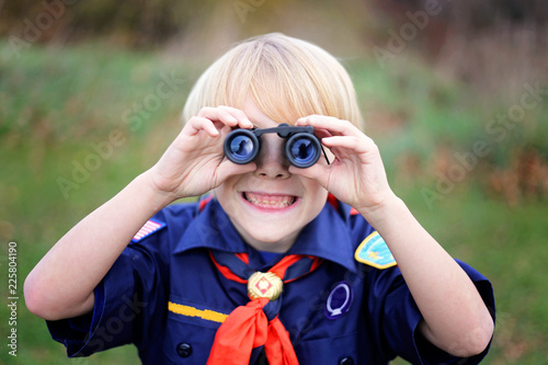 Young Tiger Cub Scout Smiling at Camera Through Binoculars