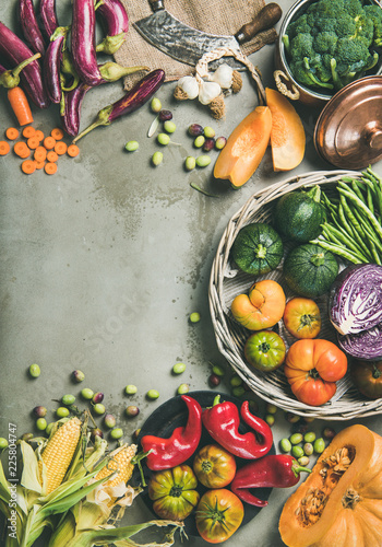 Healthy vegetarian seasonal Fall food cooking background. Flat-lay of Autumn vegetables over grey concrete background, top view, copy space, vertical composition. Vegan, alkaline diet food