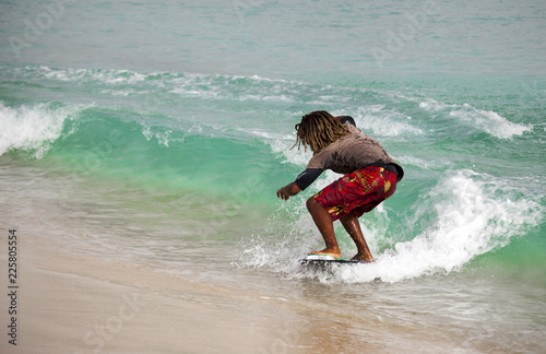 Surfing. A young man slides on a Board on the waves of the ocean. Cape Verde