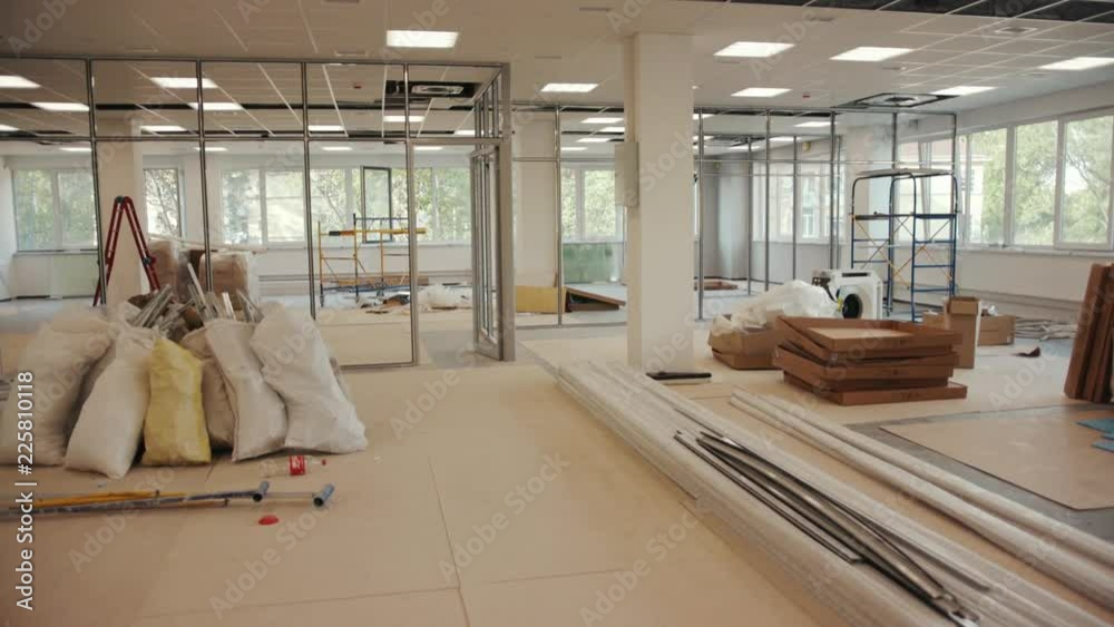The office is in repair white walls light burning building materials builder building construction contractor engineer industrial male renovation technician development design project slow motion