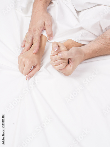 Fototapeta hands of couple pulling white sheets in lust and orgasm