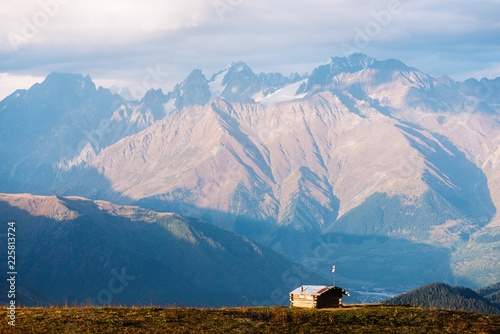 Mountain landscape with peak in clouds and hut photo