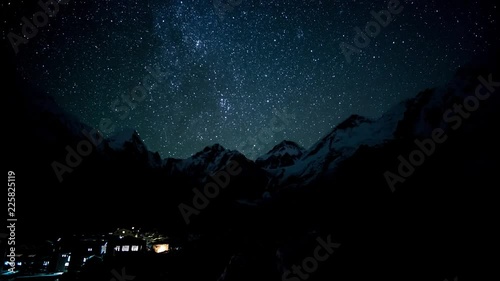 Timelapse of The movement of the stars in the night sky over Everest. Under the mountain is the village in which the Sherpas live. Nepal. Himalayas. 4K photo