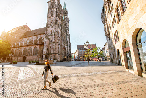Morning view on the saint Lorenz cathedral with woman walking in the old town of Nurnberg, Germany