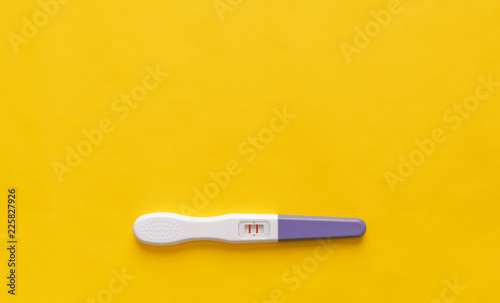 Pregnancy test on a yellow background. Close-up.