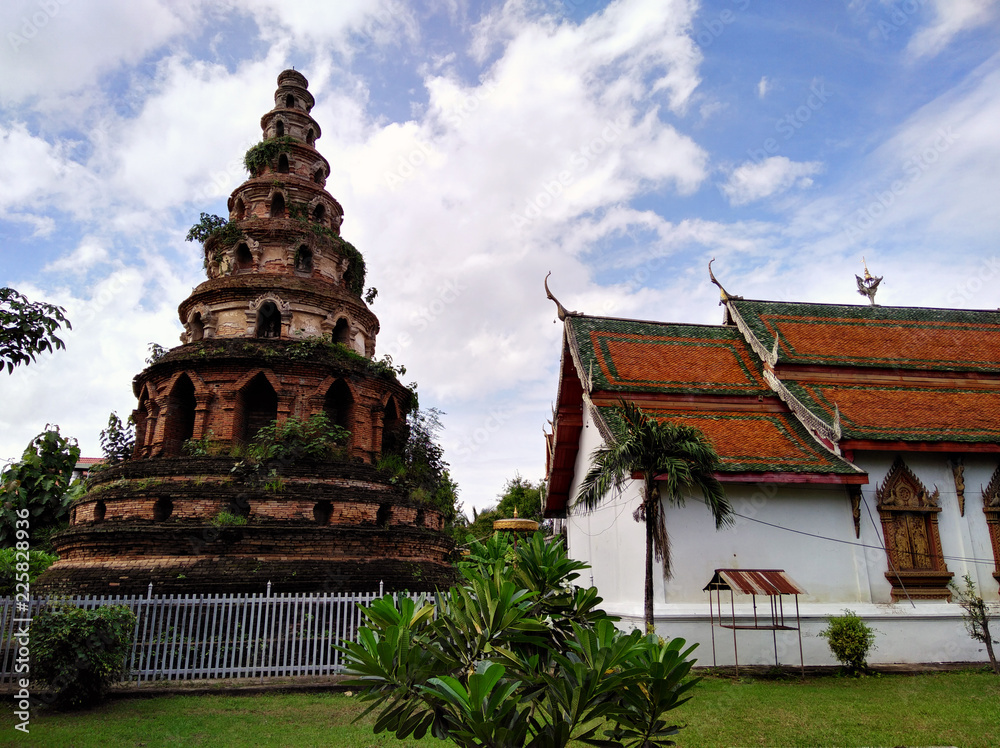 Red brick stupa temple near beautiful building with red roof. Traditional architecture in Chiang Mai, Thailand. Red brick stupa temple near beautiful building with red roof. Traditional architecture in Chiang Mai, Thailand.