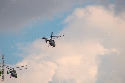 Helicopters fly away on a background of clouds