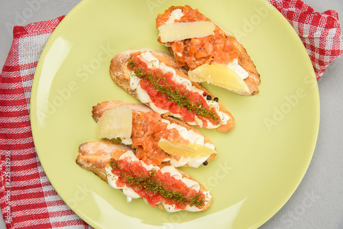 Bruscheta with tomato. Bruscheta with salmon and lemon. Bruschety on a yellow plate photo