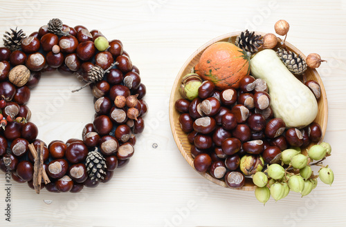 Chestnuts and autumn decorations on a wooden background. photo