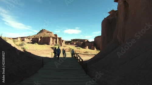 Talampaya National Park. Group of people walking over wood runway beside rocky geological formations made by wind and water erosion, in Rioja Province, Argentina. World Natural Heritage photo