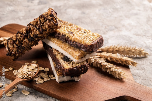 Mixed gluten free granola cereal energy bar with dried fruit & various nuts, gray concrete background. Healthy vegan super food, fitness dieting snack for sporty lifestyle. Top view, copy space.