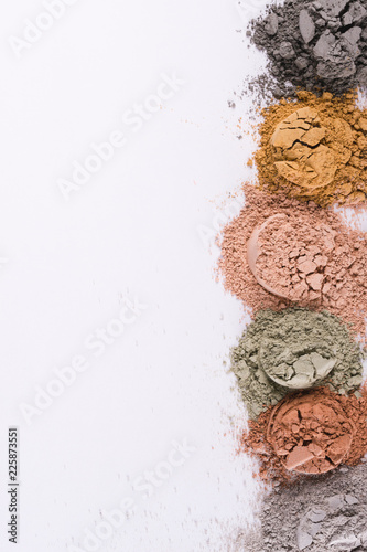 Set of different cosmetic clay mud powders on white background