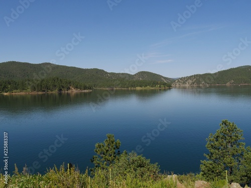 Beautiful view of Pactola Lake in the Black Hills of South Dakota, USA, framed young trees in the foreground. photo