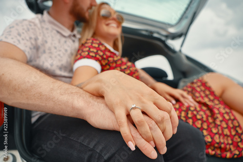 Close up of engaged couple holding hands with diamond ring