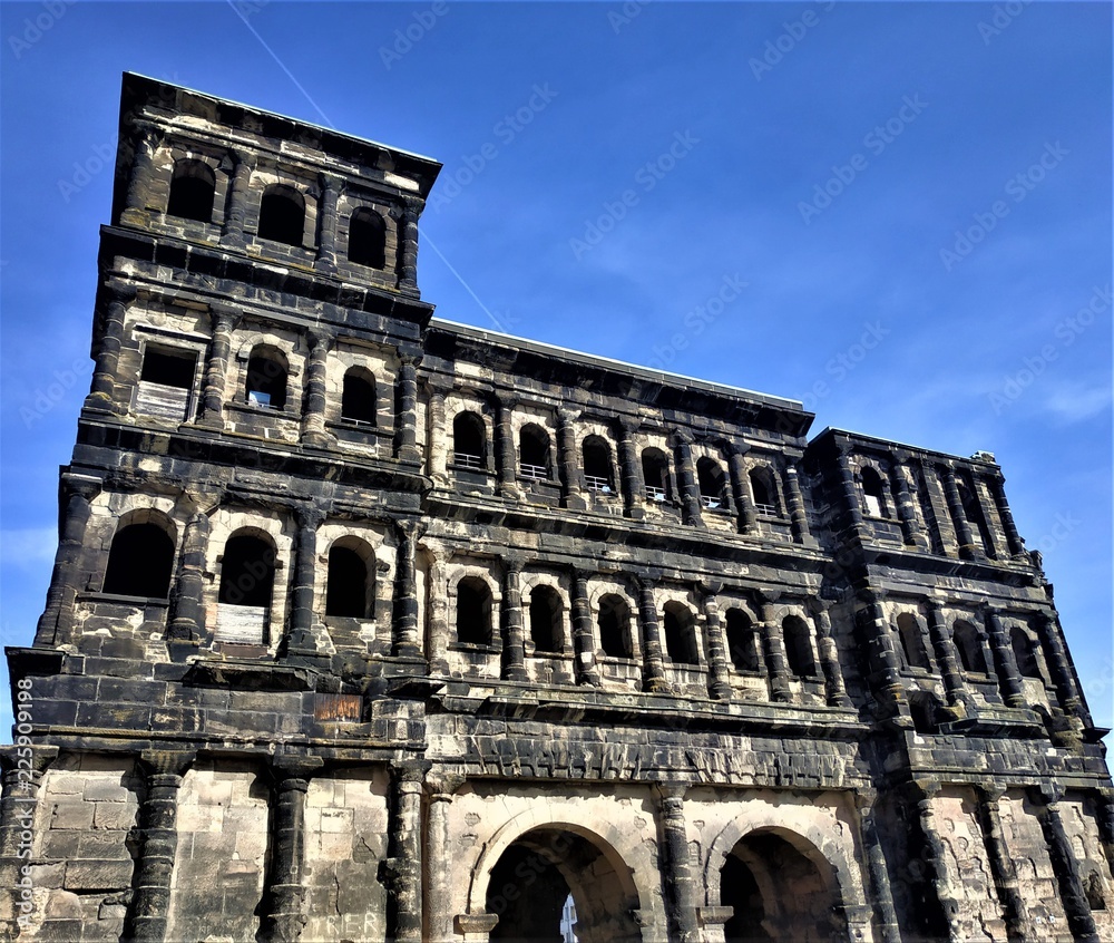Impressive porta nigra gate in front of blue sky in Trier