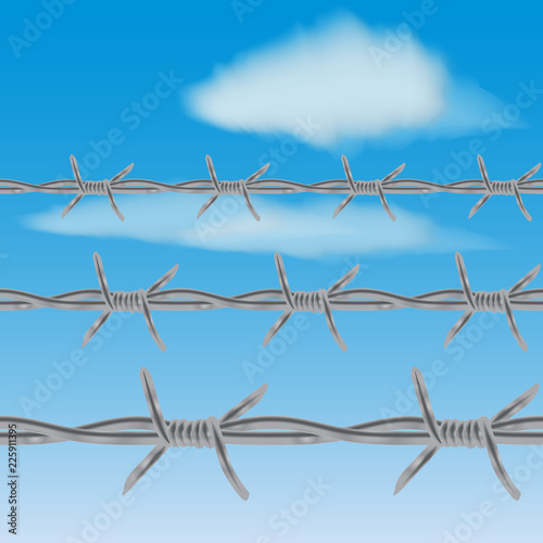 barbed wire fence against blue sky and clouds