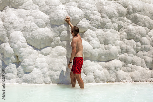 Man posing near the thermal springs and travertines of Pamukkale photo